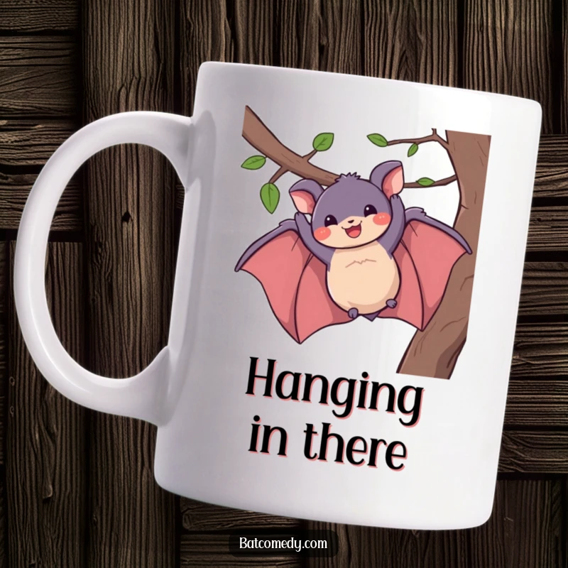 Funny mug shows a playful bat happily dangling from a branch with a wide, grinning smile, a humorous treat.