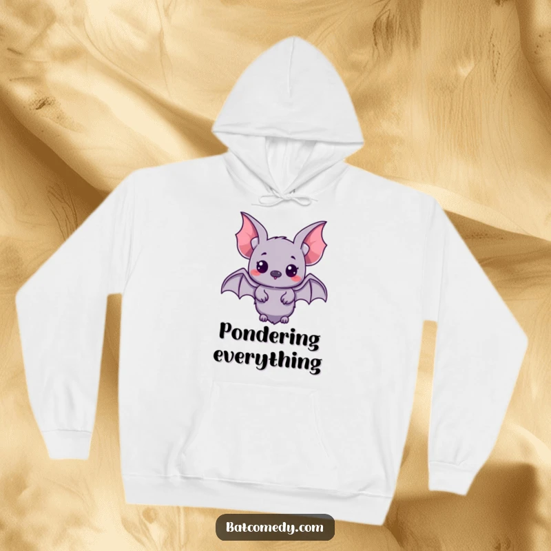 Funny kawaii bat with small wings spread, looking with wide, curious eyes on a cozy hoodie.