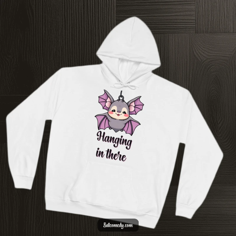 Funny kawaii bat with a wide, silly grin hanging upside down, bringing cozy humor to a plush hoodie design.