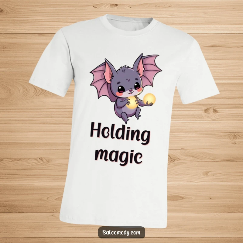 Funny bat t-shirt depicting a bat holding a small, luminous orb in its claws, representing hope and inner light.